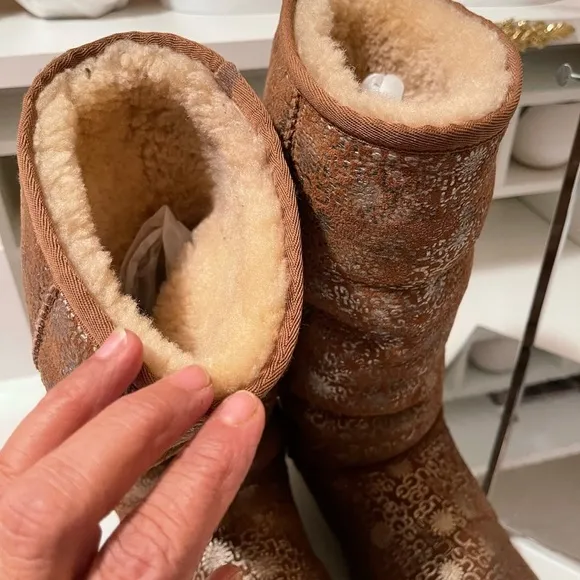 Uggs boots with light gold color logos all around the boots tan and gold