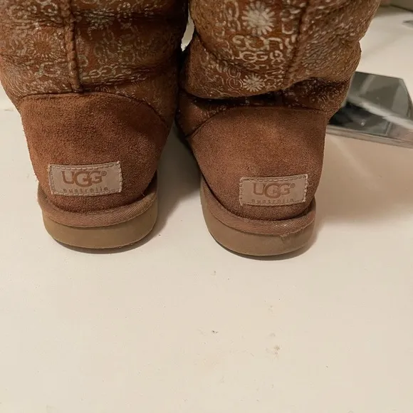 Uggs boots with light gold color logos all around the boots tan and gold