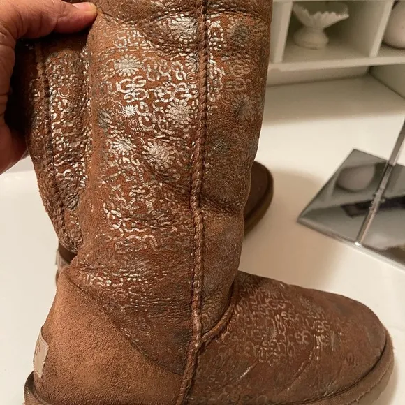 Uggs boots with light gold color logos all around the boots tan and gold
