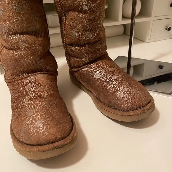 Uggs boots with light gold color logos all around the boots tan and gold