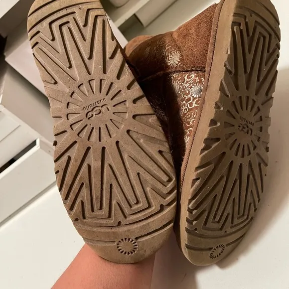 Uggs boots with light gold color logos all around the boots tan and gold