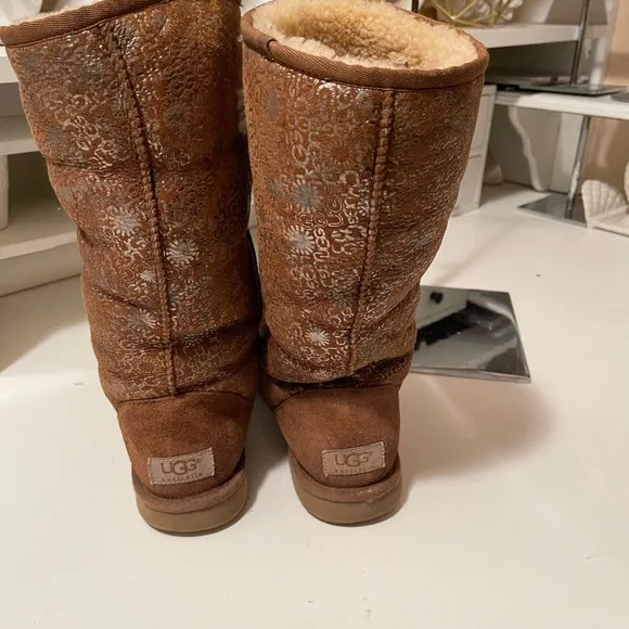 Uggs boots with light gold color logos all around the boots tan and gold