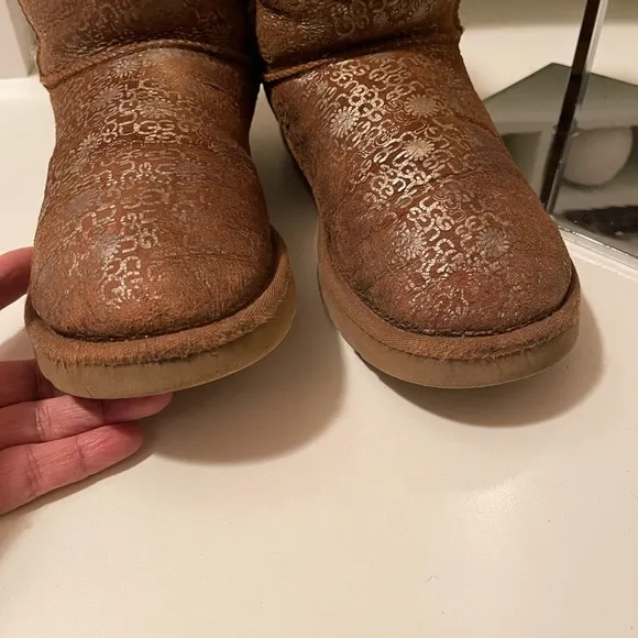 Uggs boots with light gold color logos all around the boots tan and gold
