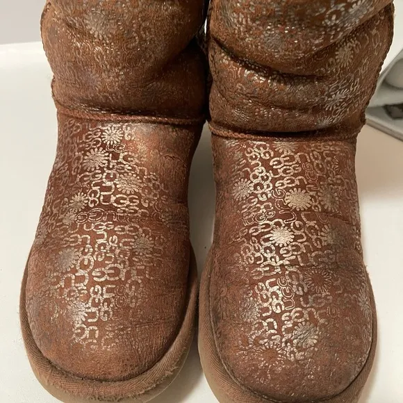 Uggs boots with light gold color logos all around the boots tan and gold