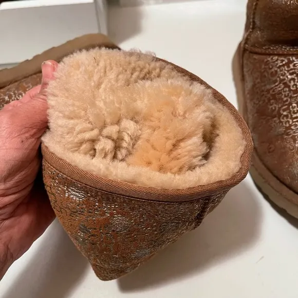 Uggs boots with light gold color logos all around the boots tan and gold