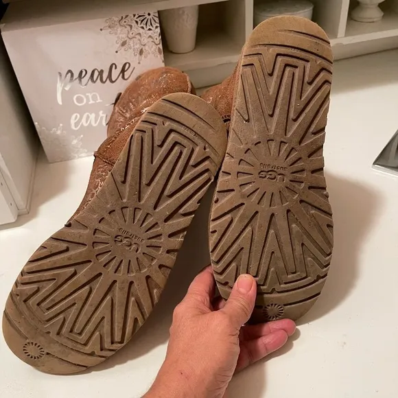 Uggs boots with light gold color logos all around the boots tan and gold